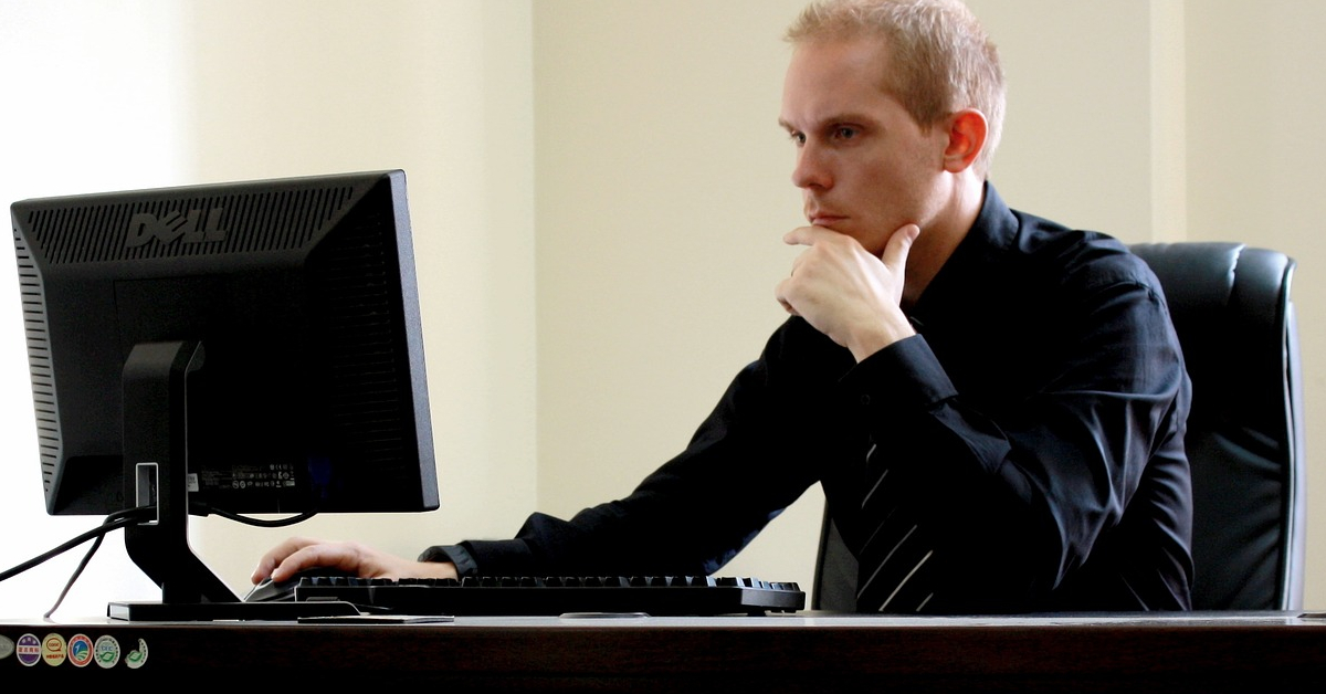 Man looking at computer screen thinking