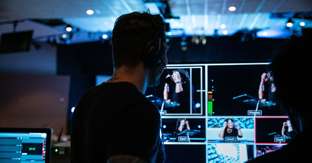 Producer with headset looking at tv