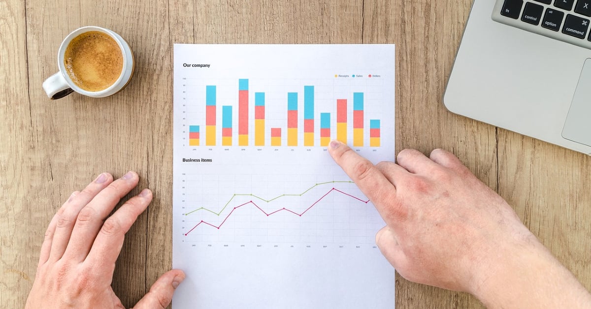 Two hands with graphs of sales