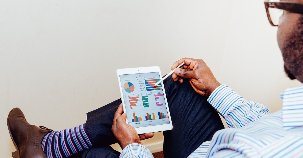 Man on tablet looking at graphs